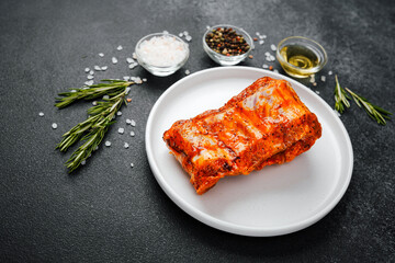 Marinated pork ribs on white plate with herbs and spices