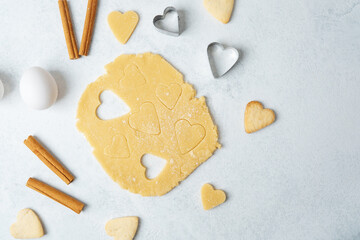 Heart shaped cookie dough cutting with cinnamon and eggs for baking, valentines or romantic concept