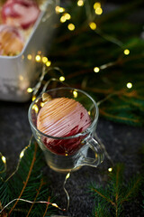 A beautifully presented dessert features a swirl of cream atop a delicate pastry in a clear glass cup