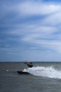 Kitesurfer creating water splash while riding at high speed on water