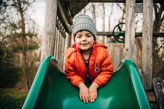 Young boy playing on slide at playground
