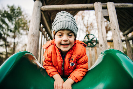 Happy boy playing on a slide in winter