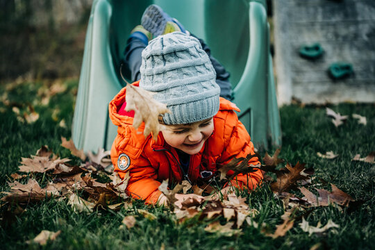 Toddler playing in autumn leaves feeling joy and happiness