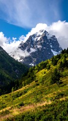 Obraz premium Majestic mountain peak rising above verdant valley with scattered clouds
