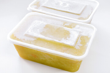 Frozen soup in a plastic box container. Potato leek soup in a box. Photo can be used for the concept of is frozen food healthy to eat or how do you keep frozen food fresh.