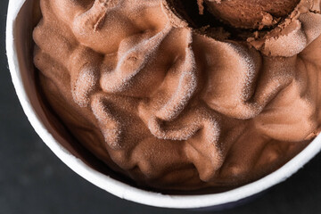 Frozen chocolate ice cream swirl in paper cup top view