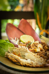 Traditional Thai Pad Thai with river prawn and banana blossom served on rustic wooden background