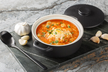 Zurrukutuna cod, garlic, red pepper, egg and bread soup closeup in the saucepan on the table. Horizontal