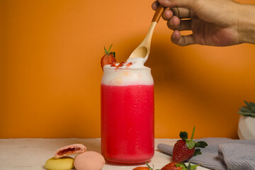 Refreshing strawberry milk with whipped cream served in a glass jar.
