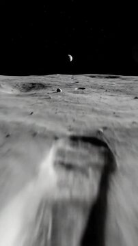 Monochromatic view of cratered lunar terrain stretching to a dark, star-dusted sky with a distant crescent