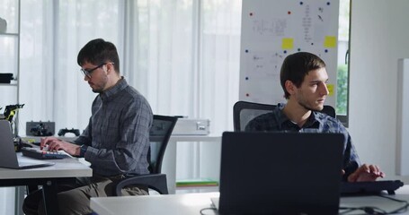 Adult male engineer team discusses AI software development robotic hand project use AI code solutions at tech workspace. Artificial intelligence interface, collaboration support prototype development. - Powered by Adobe