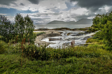 Fishing boat and fishing hut on a rainy day in Norway with a dramatic sky