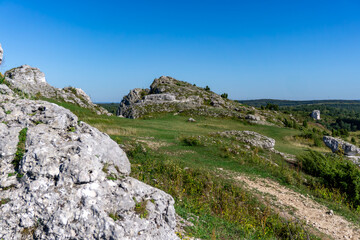Limestone hills and rock formations in Olsztyn on the Kraków-Częstochowa Upland, natural limestone landscape with vegetation and hiking trail of the Eagles’ Nests Route