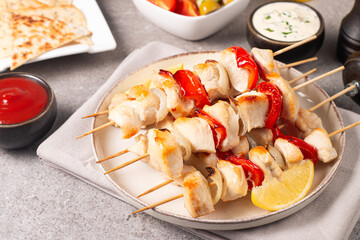 Grilled chicken skewers. Satay with side lemon and salad. Kebab with sauces. 