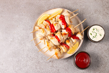 Grilled chicken skewers. Satay with side lemon and salad. Kebab with sauces. 
