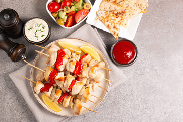 Grilled chicken skewers. Satay with side lemon and salad. Kebab with sauces. 