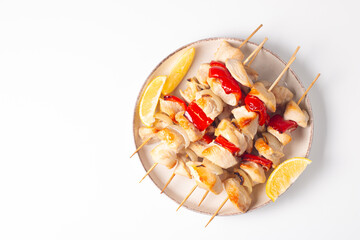 Grilled chicken skewers. Satay with side lemon and salad. Kebab with sauces. 