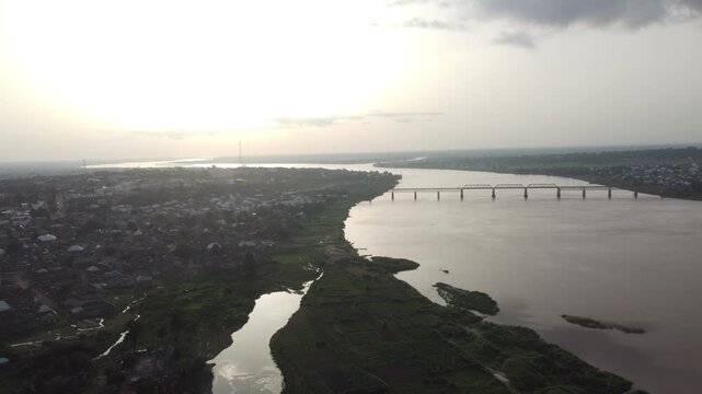 Aerial view of the Benue River with a bridge crossing the water, contrasting the natural river with the man-made structure, Makurdi, Benue, Nigeria.