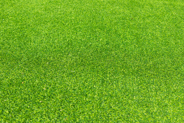 Fototapeta premium Close-up of lush green artificial grass, showcasing its detailed texture and vibrant color, perfect for outdoor landscaping and sports fields.