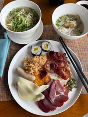 Vietnam, A breakfast plate with bacon, cured meat, cheese, dried squid, and a flavorful national soup. Resort dining experience