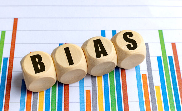Bias word on round wooden blocks placed on colorful statistical bar chart background
