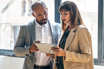 Business team discussing financial strategy with tablet in office