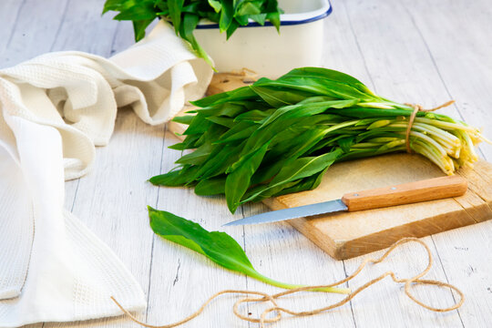 Wild garlic ramsons and knife on cutting board in rustic kitchen