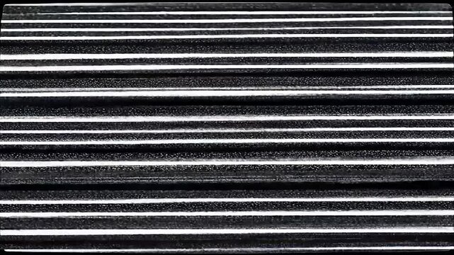 Horizontal layers of rough dark material alternating with bright smooth thin white strips