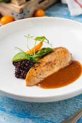 Grilled chicken fillet with black rice and vegetables in sauce