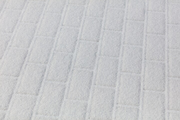 A white brick wall with snow on it