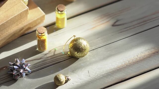 Holiday decor. Packing holiday gifts. Gift boxes, silver bow and Christmas gold balls against the backdrop of the Christmas tree and golden bokeh