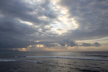 The sky is cloudy and the sun is setting