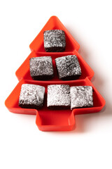 Chocolate brownies with powdered sugar in Christmas tree tray on white background