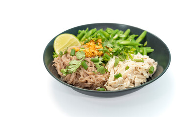 Dry noodles with pure chicken (high protein), brown rice vermicelli, served with boiled long beans and fresh lemon on a white background. Top view.