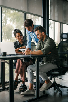 Diverse startup, business people working together on laptop computer in modern office