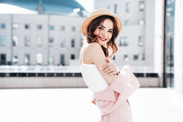 Young beautiful smiling hipster woman in trendy summer clothes. Sexy carefree female posing in the street at sunny day. Positive model outdoors. Cheerful and happy in straw hat, red lips