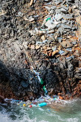 Environmental pollution in a mountain gorge — plastic waste contaminates river waters and rocky cliffs, showing the threat of plastic to fragile ecosystems