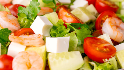 A close-up of a vegetable salad with shrimp. Fresh vegetables, feta cheese, and shrimp make for a healthy meal. High quality photo