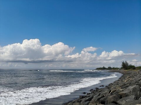 Padang Galak Beach in the afternoon with gentle waves and clear blue sky, Bali, Indonesia