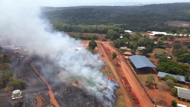 Aerial clip of a wild grass fire and smoke at the edge of a remote community in Cape York, Australia. Clip 4