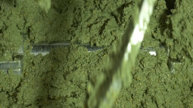 Freshly ground green olive paste (pulp or mass) being stirred in the blender. This is the key step in the olive mill before the extraction of Extra Virgin Olive Oil.