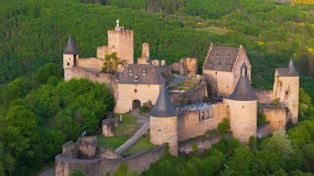 bourscheid castle ch&acirc;teau de green cover hills farms entry area cafe restaurant chairs rooftop luxembourg reveals from around pull pullback drone shot 