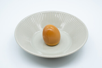 Boiled eggs in a circular bowl on a white background