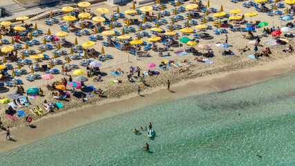 Aerial view of Mondello Beach near Palermo, Sicily, Italy. It's a beautiful bay and a popular tourist destination for Sicilian summer holidays. There are many beach umbrellas and people on vacation. © Stefano Tammaro