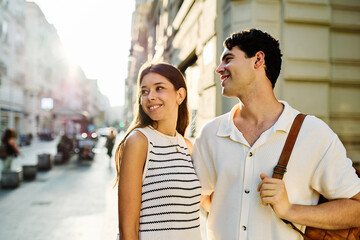 Couple enjoys a sunny day walking together in a charming urban area during late afternoon or tourists visiting a destination