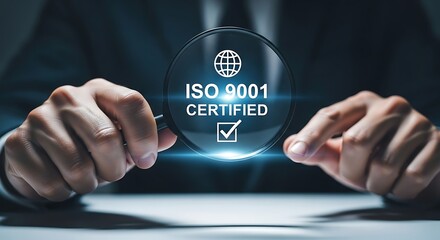 Businessman holding magnifying glass over iso 9001 certified quality management system