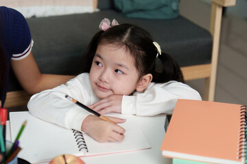 Focused Learning. Young Girl Writing with Mother Support