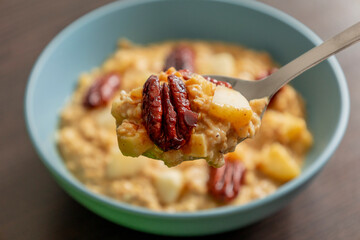 delicious oatmeal with pumpkin apple and pecans close up