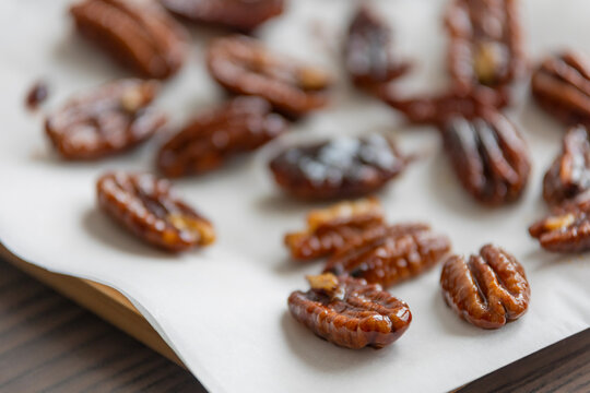 caramelized pecans on white background close up