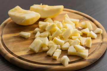 chopping fresh crisp apple on wooden cutting board close up